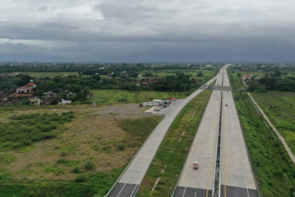 Infografis atau foto gerbang tol dengan kendaraan mengantre, menampilkan data total volume lalu lintas libur Imlek 2026 sebanyak 610 ribu kendaraan.
