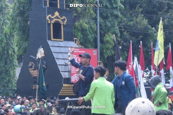 Ketua Umum Bapemnus Jansen Henry Kurniawan berpidato di podium dengan latar bendera organisasi.
