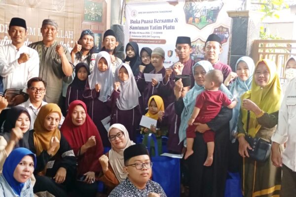 Ketua DPD SWI Kabupaten Tangerang Karjoni, S.E. didampingi Dewan Pembina Imam Suwandi, S.Sos., M.I.Kom sedang menyerahkan santunan kepada anak yatim piatu binaan GBI dan Baitul Atiyah di Sekretariat DPD SWI Tangerang, Rajeg, dalam acara Bukber dan Santunan Ramadhan 2026.