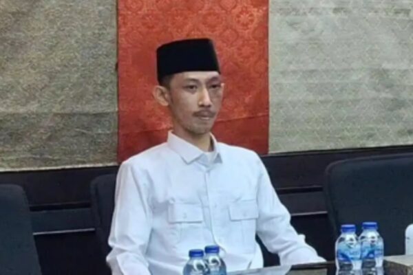 Anggota DPRD Jember Achmad Syahri tengah asyik bermain gim sambil memegang rokok di tengah rapat resmi