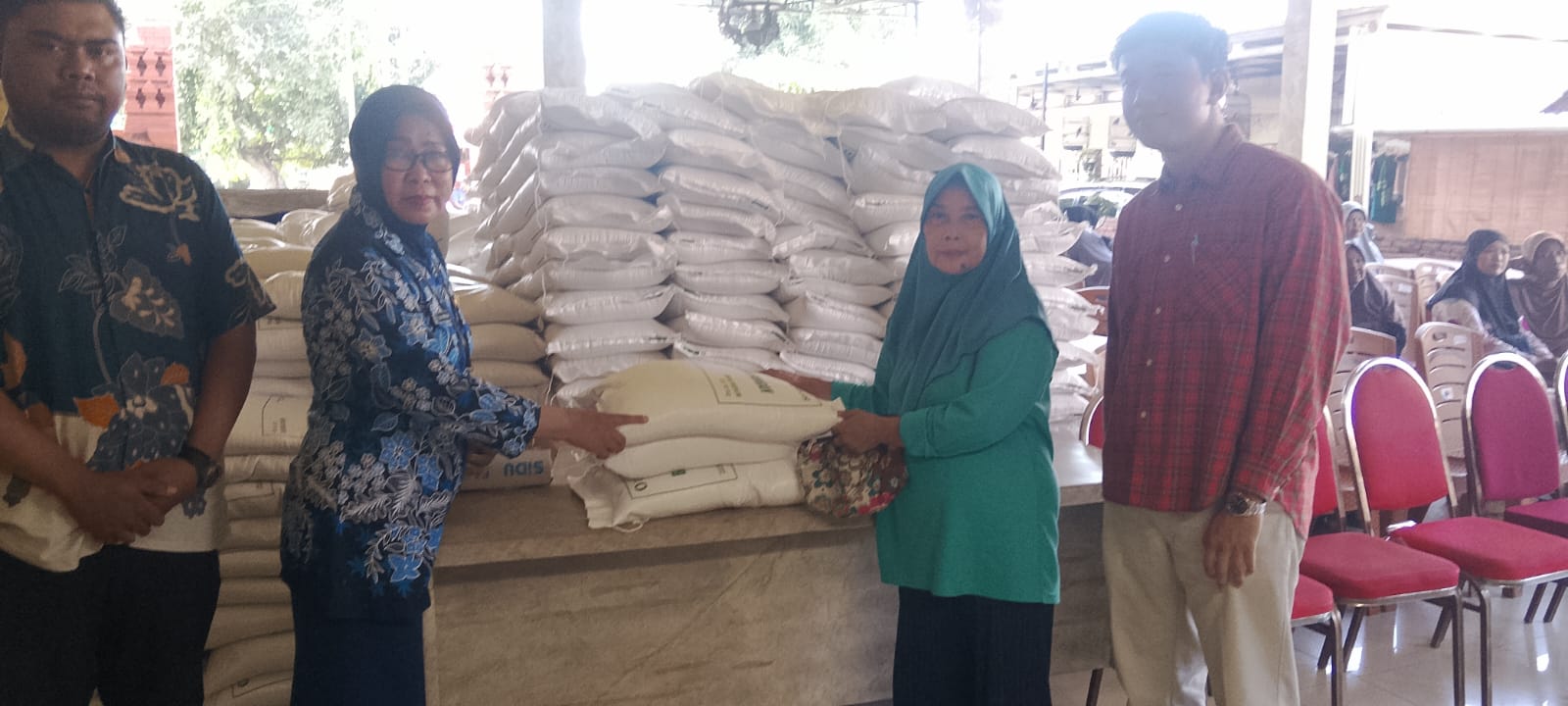 Kepala Desa Cemandi Dra Rusilah memimpin penyaluran bantuan pangan beras di Balai Desa Cemandi."