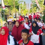 Suasana jalan sehat Desa Cemandi dengan ratusan peserta memadati jalan raya di depan Balai Desa."